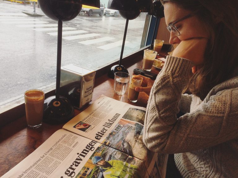 Woman reading the newspaper in a coffee shop